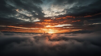 Fototapeta premium The sun sets, painting the cloud-filled sky with dark oranges and yellows