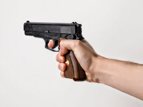Primer plano de una mano armada con una pistola apuntando concepto de violencia defensa, robo 