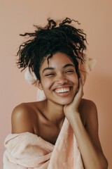 Joyful young black woman with towel smiling against beige background