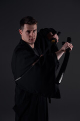 Samurai ninja warrior in kimono in attack pose with katana sword. dark room. sword shine. fighter. japanese culture