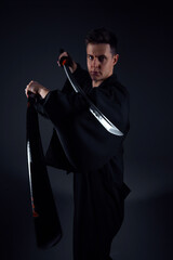 Samurai ninja warrior in kimono in attack pose with katana sword. dark room. sword shine. fighter. japanese culture