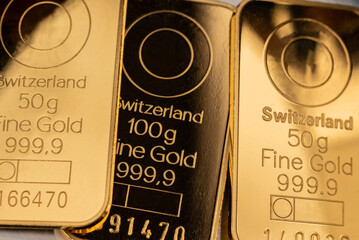 Several minted gold bars of different weights. Selective focus.