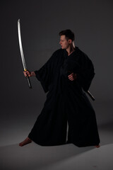 Samurai ninja warrior in kimono in attack pose with katana sword. dark room. sword shine. fighter. japanese culture