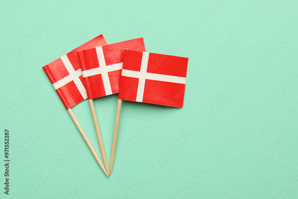 Poster Small paper flags of Denmark on turquoise background, top view. Space for text