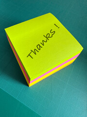 The word thanks written on a post it pad in English