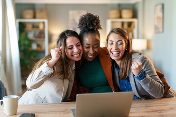 Joyful Businesswomen Collaborating with Laptop in Office