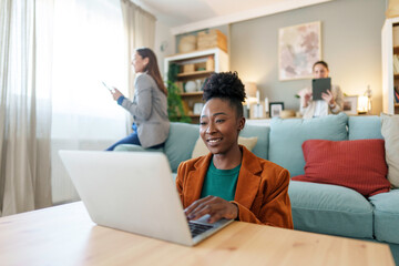 Focused Professional Black Female Working on Laptop in Office Lounge