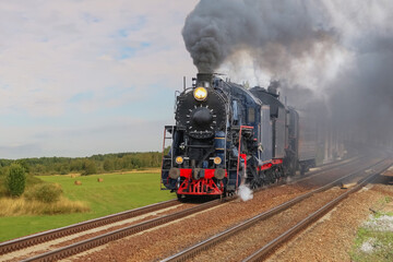 Retro Steam Locomotive Traveling Along Railroad Along Rural Fields
