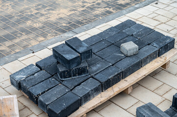 Paving stones for laying pedestrian paths stacked on a construction pallet.