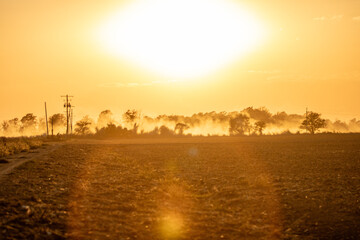 Dusty dirt road at sunset