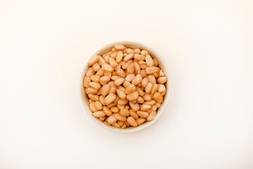 Pine nuts on a white plate. Hazelnuts.