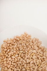 Pine nuts on a white plate. Hazelnuts.