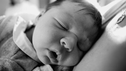 Black and white close-up of a newborn baby asleep on mother&rsquo;s chest, evoking a timeless sense of peace, comfort, and the deep bond between mother and child