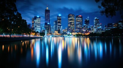 Obraz premium A vibrant city skyline reflected on water at night, showcasing urban beauty and tranquility.