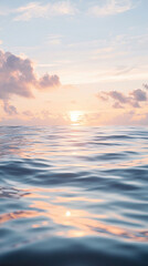 Obraz premium A serene lagoon with gently rippling water reflects soft clouds and sunset