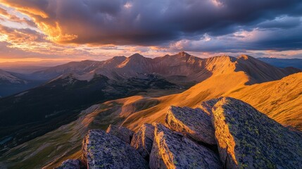 Obraz premium A stunning sunset over rugged mountains, showcasing vibrant colors and dramatic cloud formations.