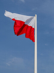 Polish banner flying against the blue sky.
