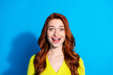 Photo of impressed funny girl with ginger hairstyle dressed yellow knit cardigan astonished staring isolated on blue color background