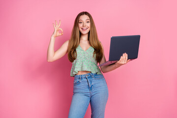 Portrait of pretty young girl laptop okey symbol wear top isolated on pink color background