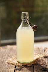 Fresh natural whey in a glass bottle outdoors