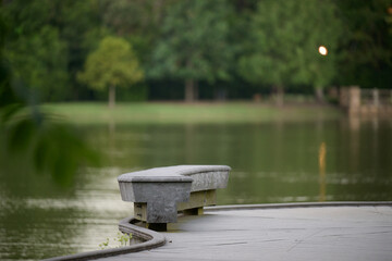 THE WOODLANDS, TEXAS - AUGUST 12th, 2024: Rob Fleming Park looks picturesque on a cloudy day. The shimmering lake and fountain reflect beautifully, while stone and wooden structures add to its chic.