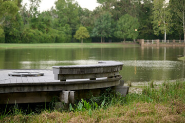 THE WOODLANDS, TEXAS - AUGUST 12th, 2024: Rob Fleming Park looks picturesque on a cloudy day. The shimmering lake and fountain reflect beautifully, while stone and wooden structures add to its chic.