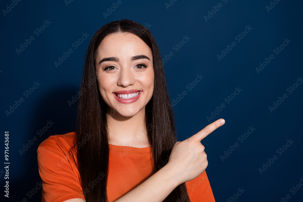 Wall mural Photo of lovely cute nice woman wear stylish orange clothes presenting empty space isolated on dark blue color background