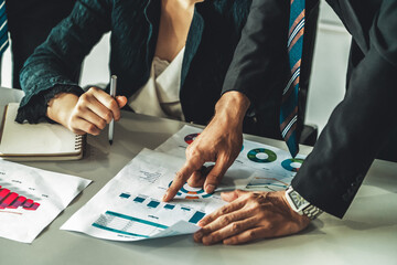 Businessman and businesswoman in meeting working with many financial statement document on desk. Concept of busy business profit analysis and brainstorm. Close up shot at people hands and papers. uds