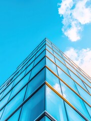 A modern glass building reaching towards a bright blue sky, showcasing sleek architecture and vibrant reflections.