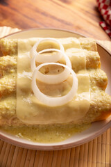 Mexican food. Enchiladas with creamy green sauce filled with shredded chicken meat and covered with melted cheese, in Mexico they are called Swiss Enchiladas. Very popular recipe in Mexican cuisine.