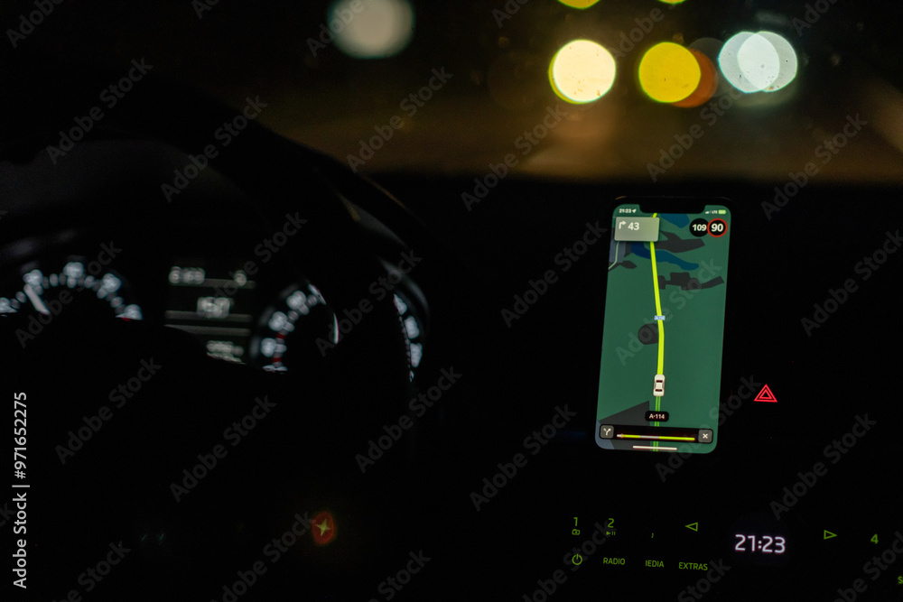 Aufkleber A person is driving in the dark, relying on a navigation app on their smartphone to guide them along the road