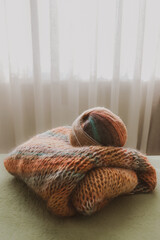 Knitted fashion. Autumn and winter wardrobe. Cozy home. Warm things. Knitting pattern. Chunky knitting. Striped clothes. Self-made cardigan. Craft product. Bright knitted mohair cardigan.