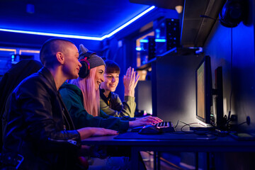 Gamer girl with headset playing mmo rpg while her friends are watching