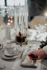 Woman hand setting up table for Christmas dinner