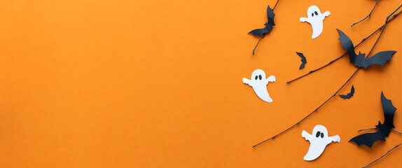 Halloween Banner: Bats, Tree Branches, and ghosts on an Orange Background