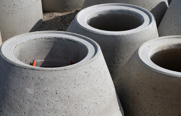 Close-up and close-up of several cone-shaped concrete pipes. The tubes are on a construction site...