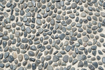 surface features cobblestone paving made from rounded stones in Italy. It showcases the texture of...