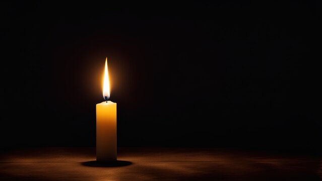 A solitary candle flame illuminates a dark space, symbolizing hope and tranquility.