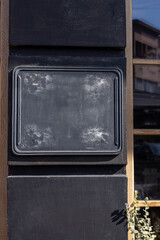 A blank chalkboard on a restaurant exterior in the afternoon sunlight