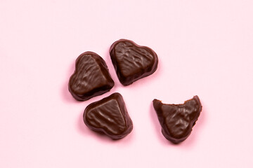 Heart-shaped chocolate candy on a pink background
