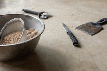 Tools and ingredients for baking bread displayed on a rustic tabletop in a cozy kitchen setting 