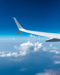 airplane window view with clouds and airplane wing