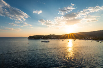 Naklejka premium Sailboat at sunset on the sea. Summer vacation in Greece. Cruise on the Ionian Sea