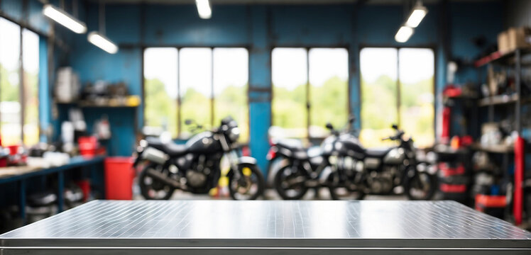 The empty stainless steel table top with blur background of Motorbike Repair Shop. For product display