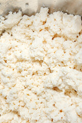 Cottage cheese top view. Homemade cheese curd texture. DIY cottage cheese recipe with milk and...