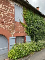 maison en pierre rouge et lierre grimpant