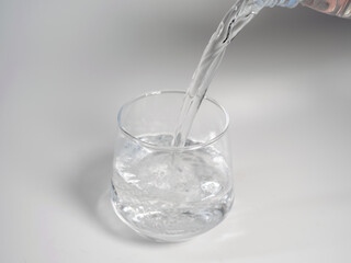 Pour Water Into Empty Glass Isolated On White Background