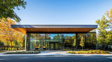 A high-end dental clinic features a sleek glass facade surrounded by vibrant autumn trees, highlighting modern architecture and inviting community accessibility