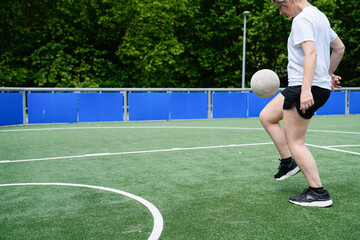 A woman kicks a soccer ball on a field