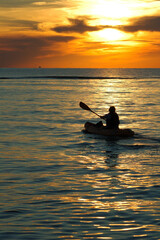 kayaking into the sunset on a calm bay at the end of a beautiful day. a relaxing sport and good exercise